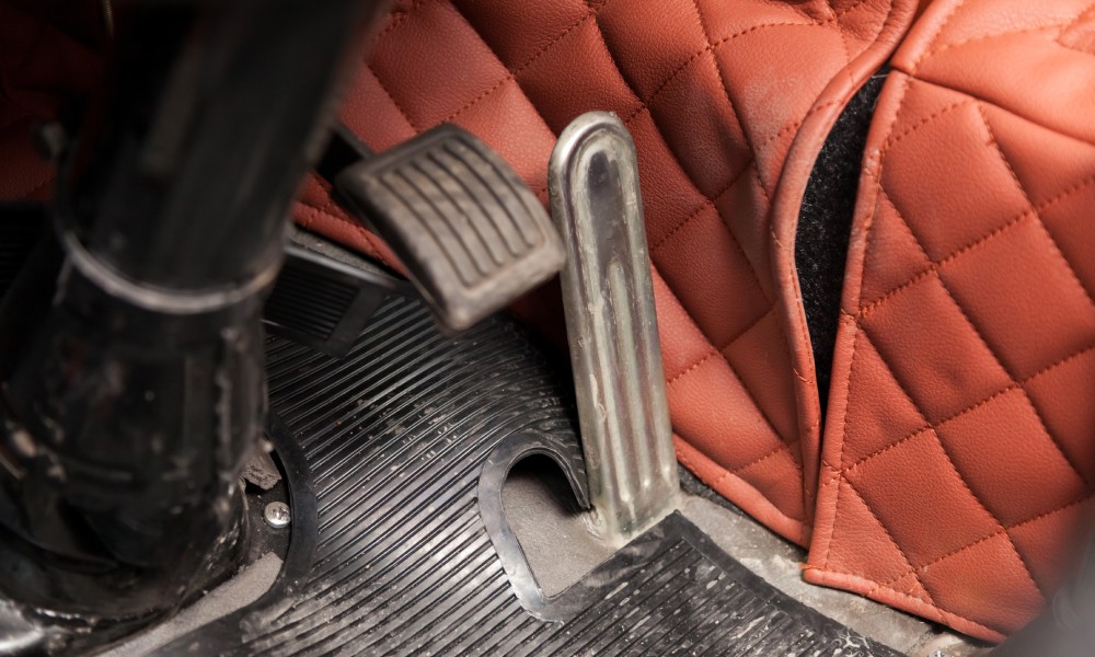 A metal brake and gas pedal in a truck, a clean floor mat, and padding protecting the center console.