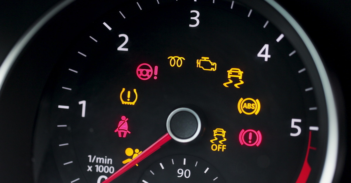 On the dash of a car, all of the warning lights are on. Some are bright yellow while others are bright red.