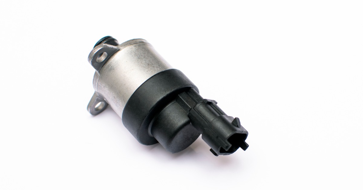 A metering valve for a fuel regulator has black and gray components. It's lying isolated on a white background.